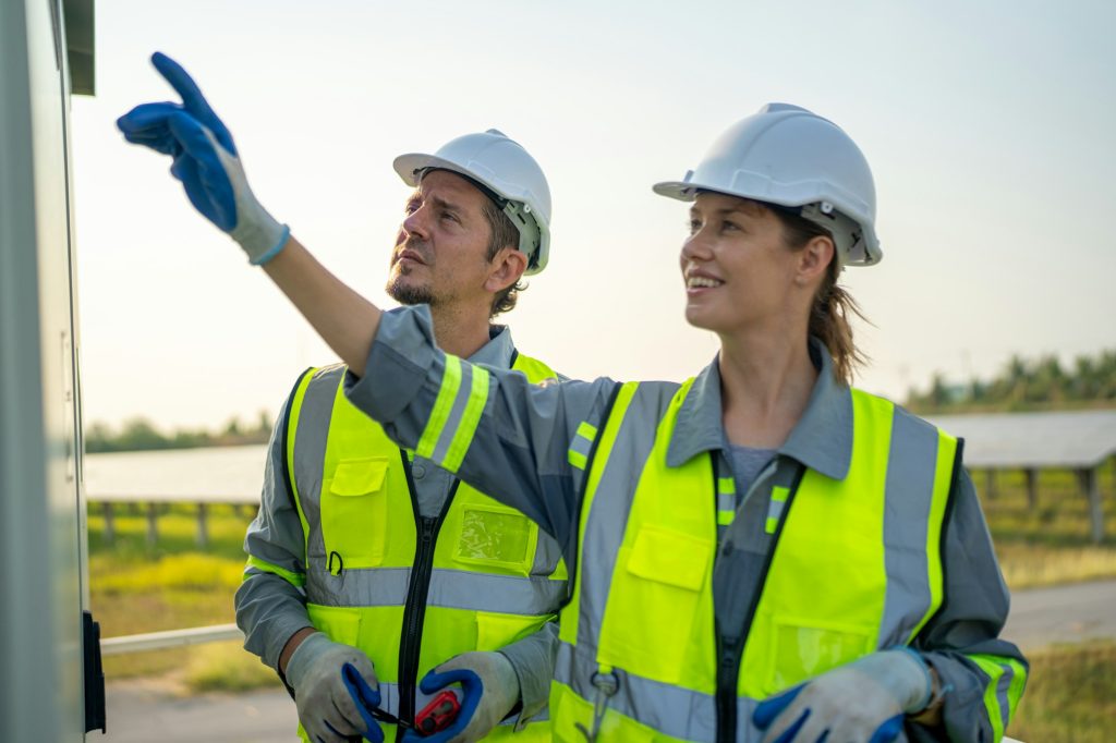 At construction site, Engineer servicing solar panel on electric plant.